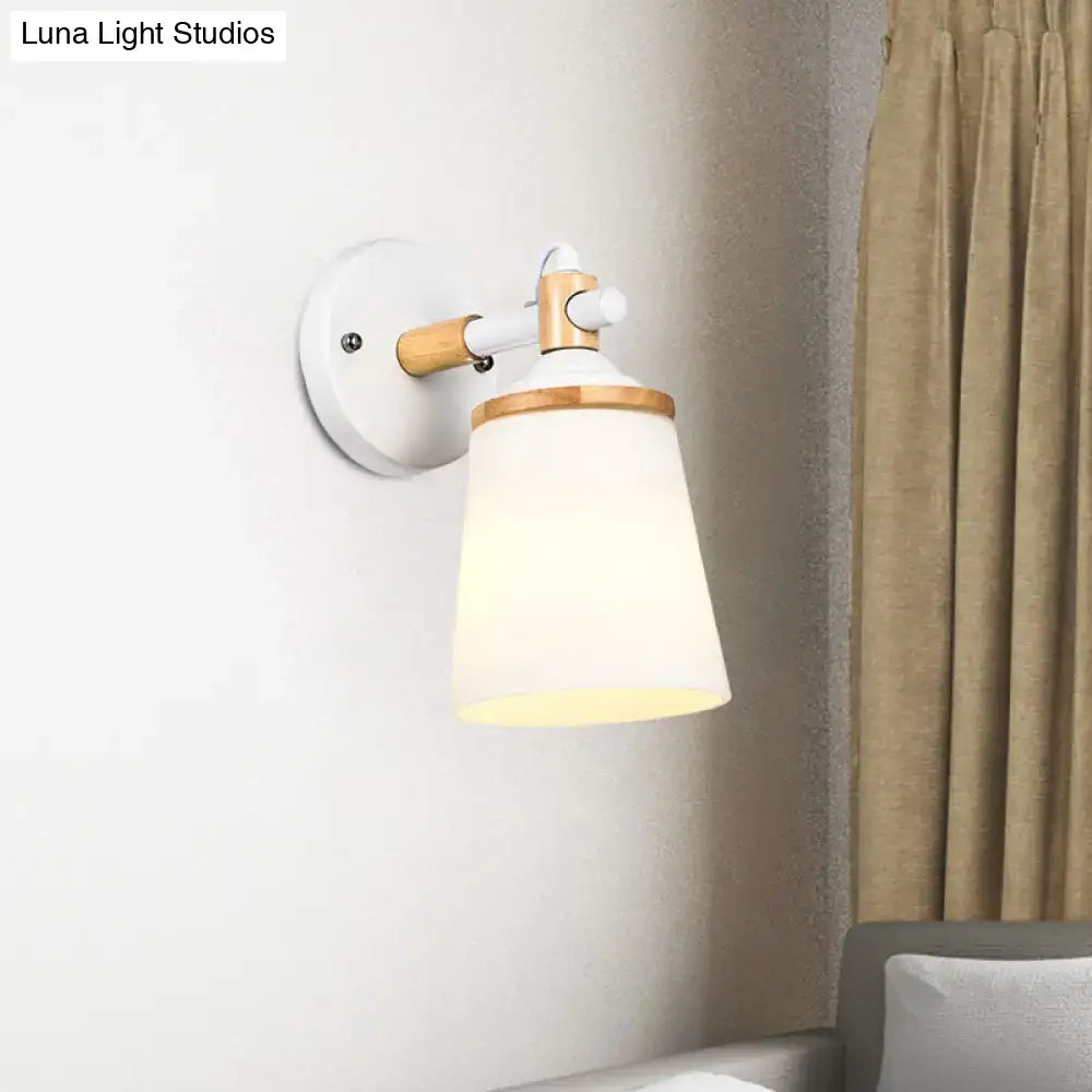 Modernist wall lamp with matte white base, light wood arm, and cream glass shade for bedroom lighting