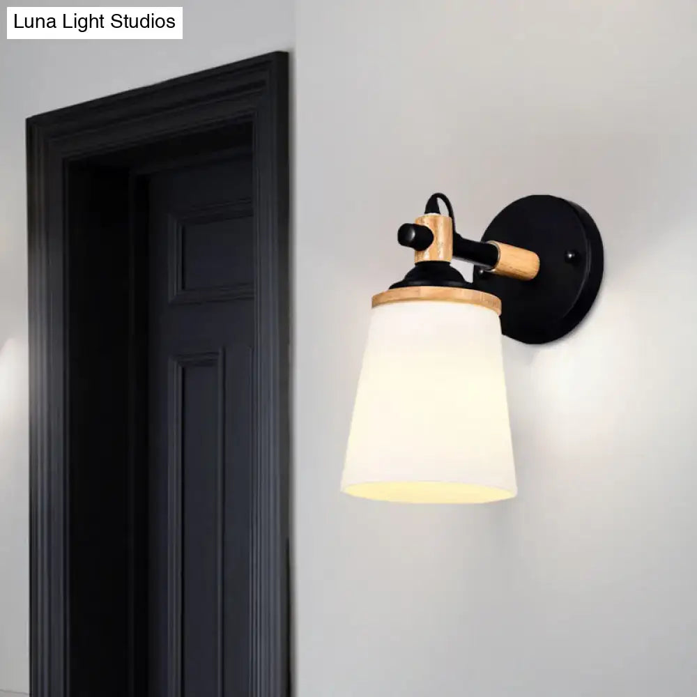 Modernist wall lamp with black and wood finish and cream glass shade for bedroom lighting