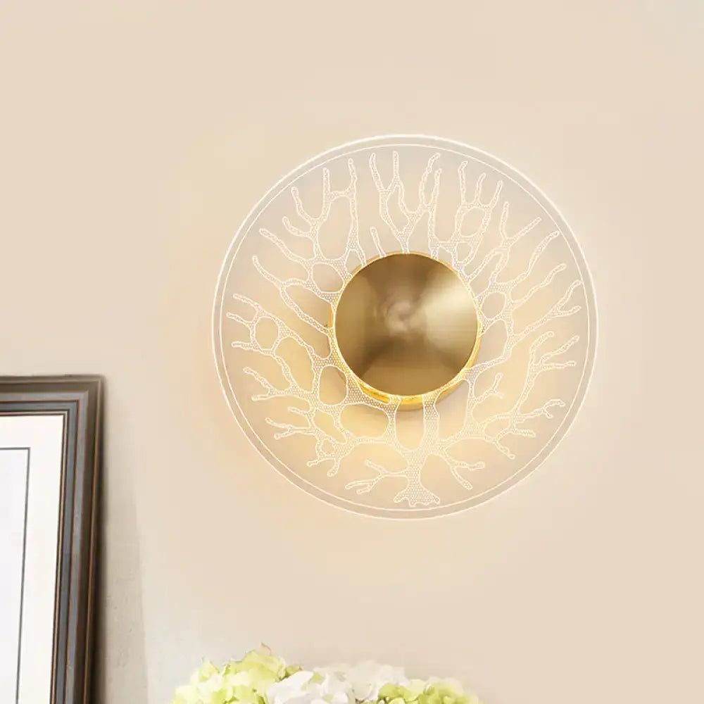 Modern style gold-toned wall light fixture with clear glass translucent shade and coral-like design for living room