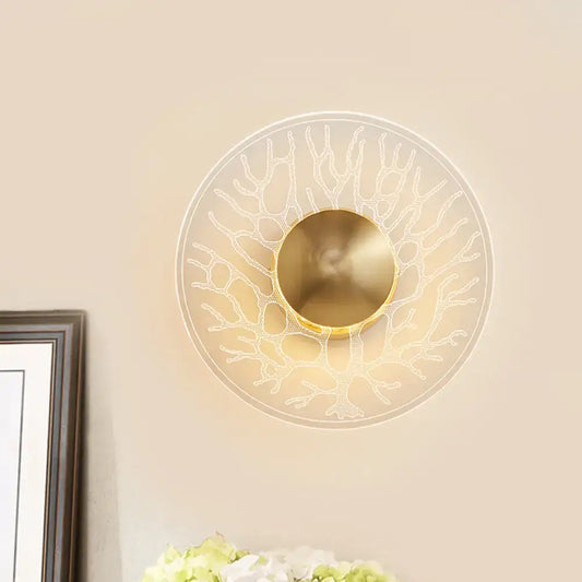 Modern style gold-toned wall light fixture with clear glass translucent shade and coral-like design for living room