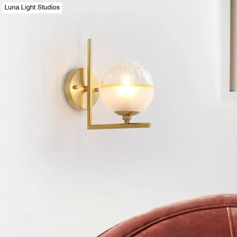 Modernist direct wired electric brass light fixture with frosted glass spherical globe and warm yellow accent band wall sconce