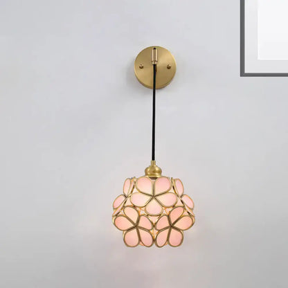 Modernist brass floral glass bulb bedside sconce with light pink handcrafted petals and black cord in a spherical bloom