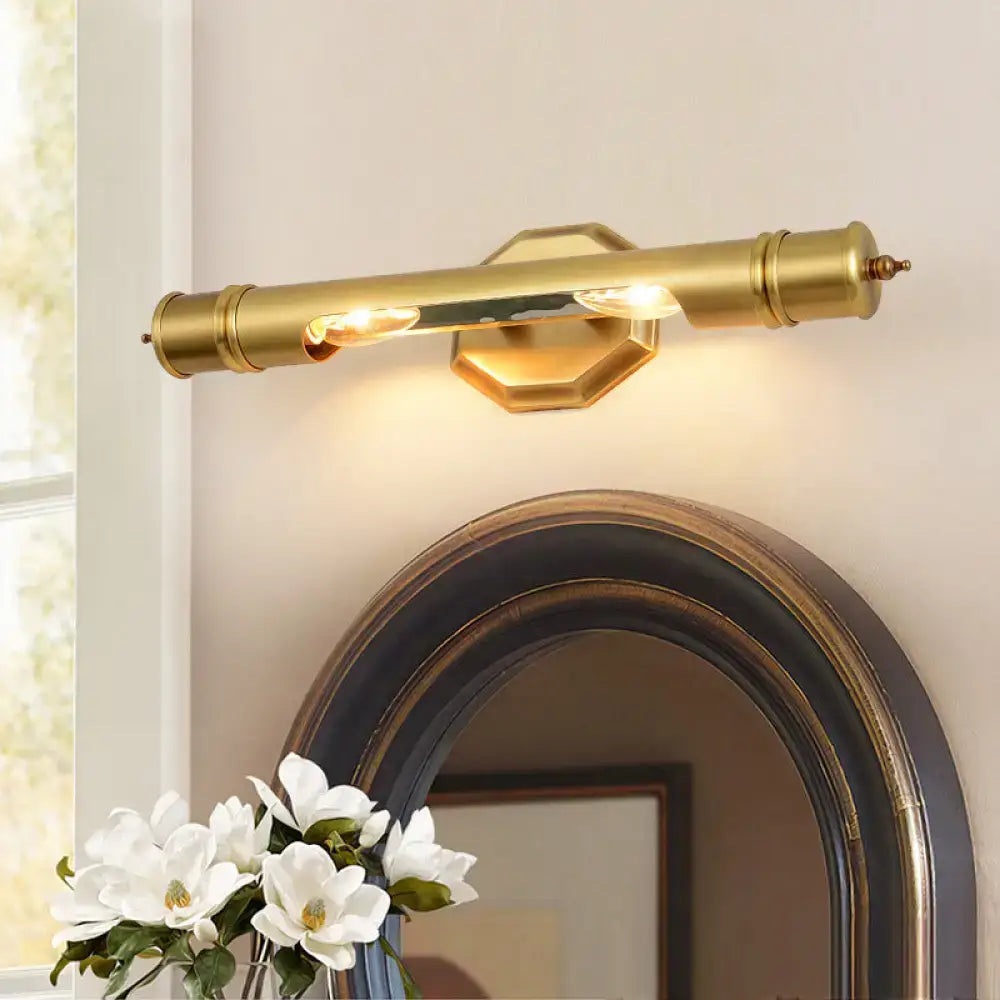 Brass-finished modernist wall sconce with sleek cylindrical design and hexagonal mount for 110-120v maximum bulb wattage