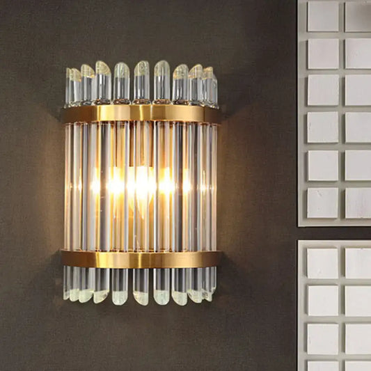 Modernist clear crystal wall sconce with gold finish and vertical glass tubes for elegant living room lighting