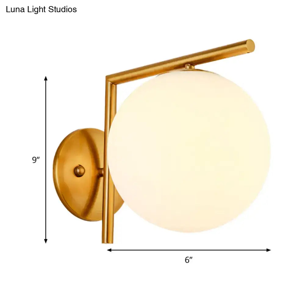 Modernist gold finished globe sconce light with frosted glass globe for bedroom wall lighting