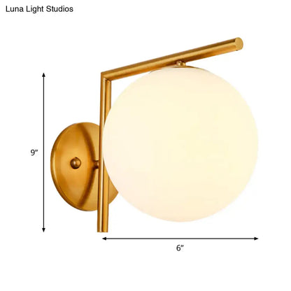 Modernist gold finished globe sconce light with frosted glass globe for bedroom wall lighting
