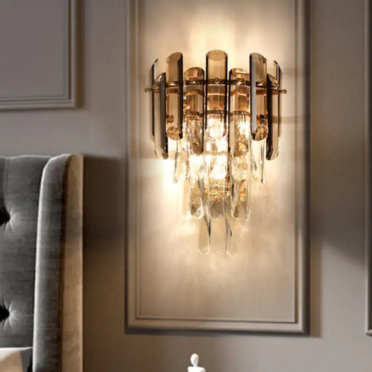 Modernist gold wall sconce with smoke gray crystal droplets and polished metal accents for bedroom wall light