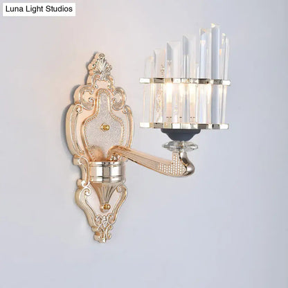 Modernist gold wall light with ornate crystal accents and curved arm featuring a conical shade for living room use