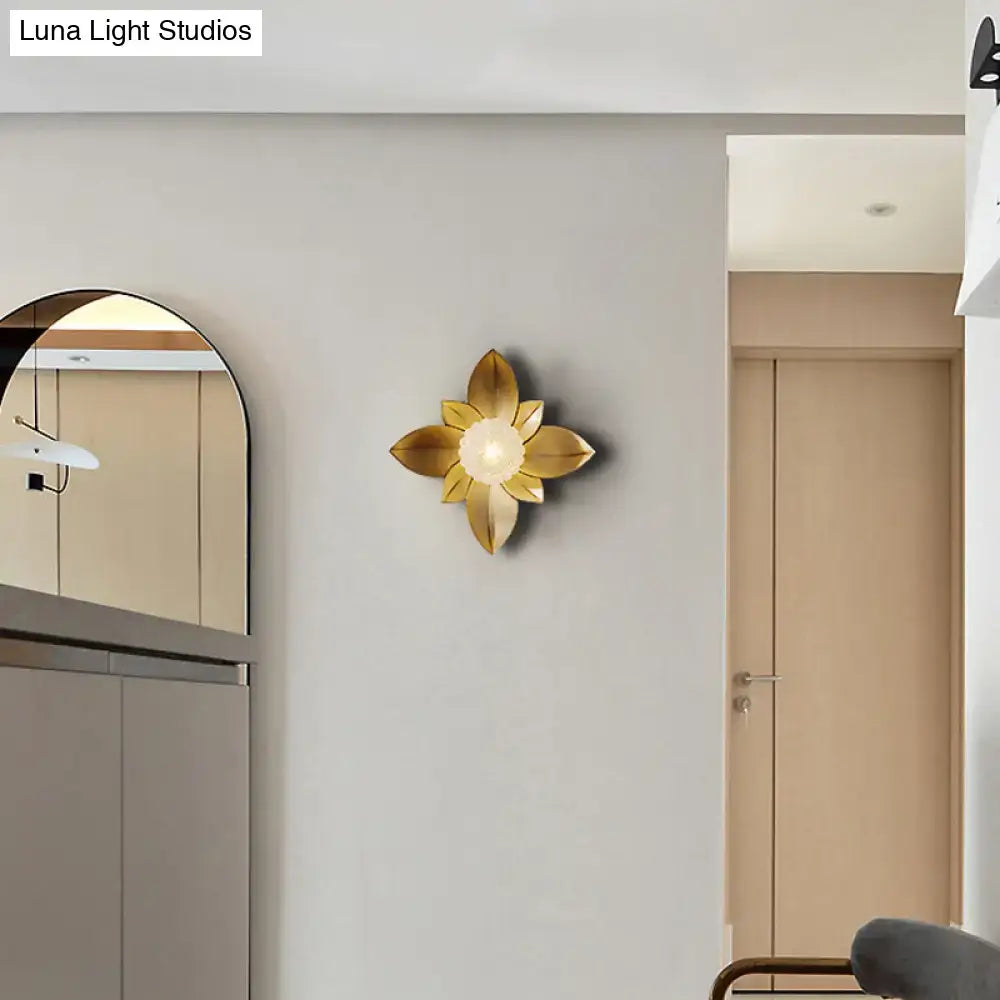 Modernist gold-toned five-petal flower light fixture wall sconce with central illuminated bulb for bedroom use
