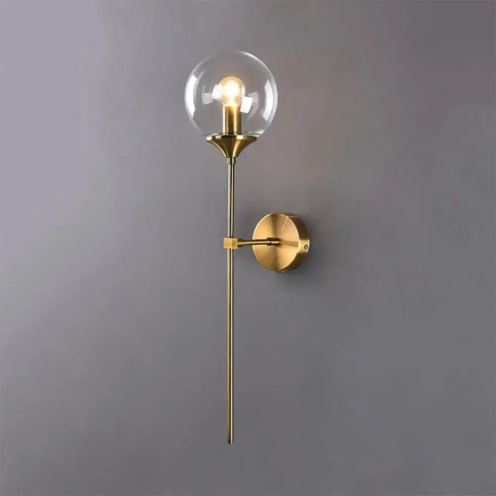 Modernist brass-finished glass round sconce lamp with clear globe and exposed bulb for living room lighting