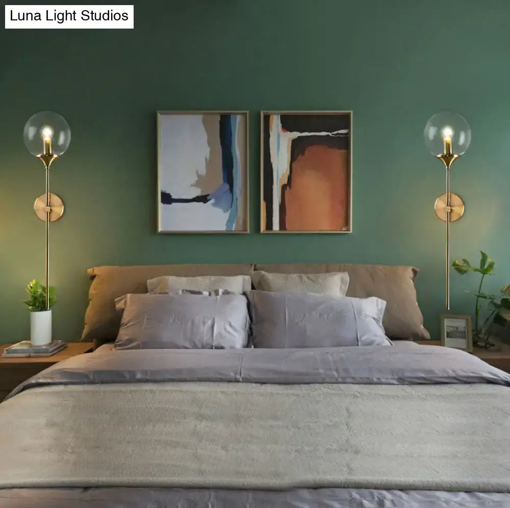 Modernist gold-toned glass round sconce lamp with clear globes and slender stems for living room use
