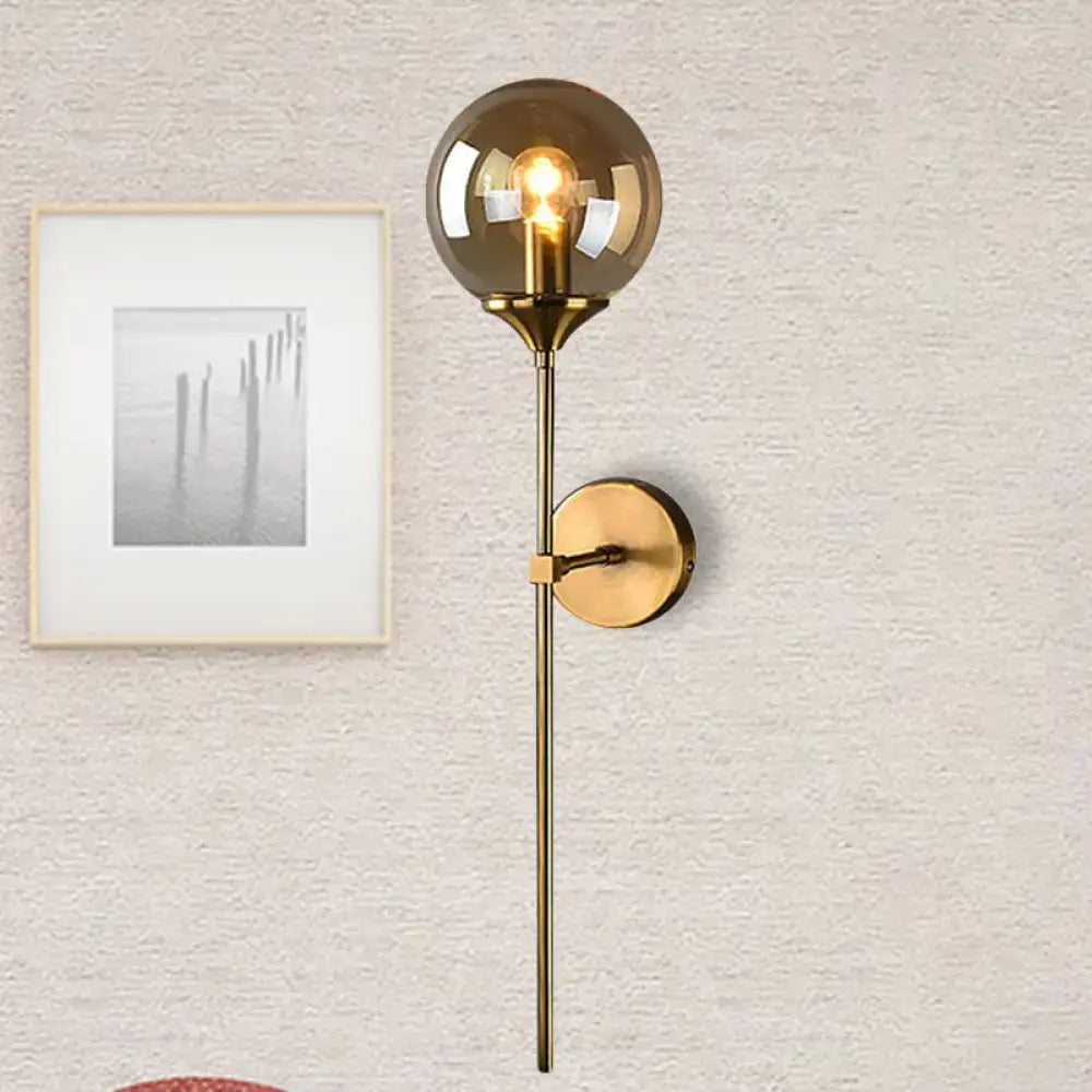 Modernist gold glass round sconce lamp with smoked glass globe and slender metal stem for living room lighting