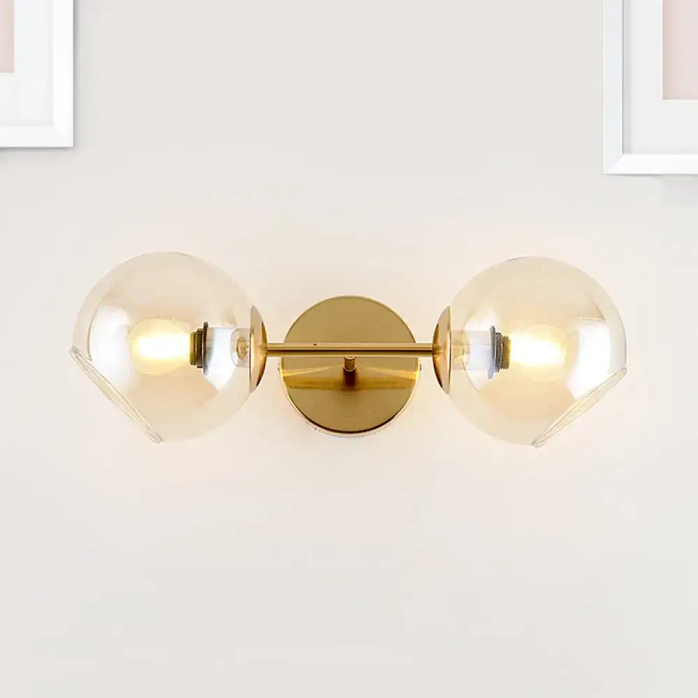 Modernist gold wall lamp with two frosted glass shades for living room featuring a gold-toned wall sconce design