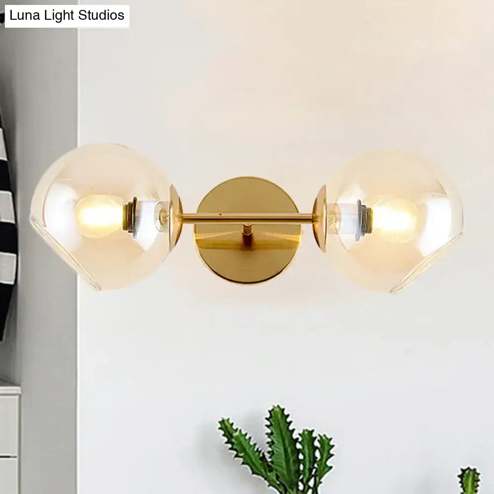 Modernist gold wall lamp with two spherical smoked glass shades for living room featuring a gold-toned finish
