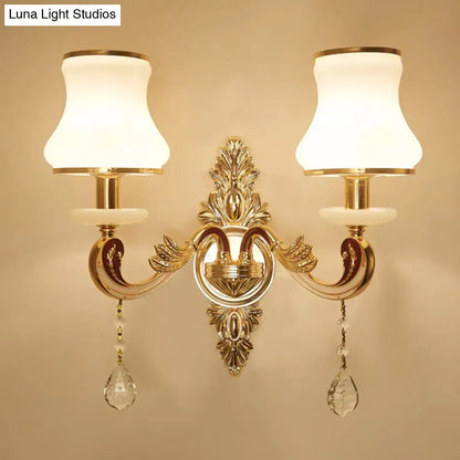 Modernist gold wall sconce with direct wired electric connection features glass shades and crystal teardrop pendants