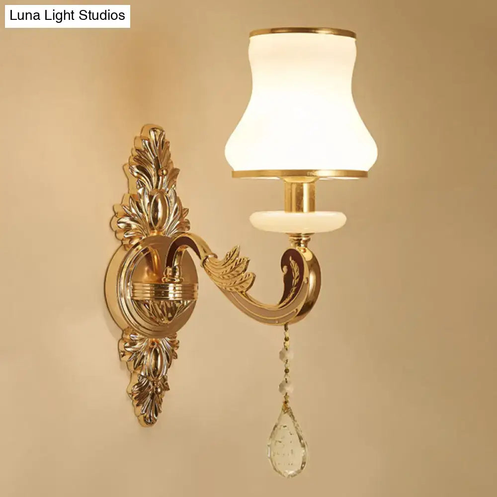 Modernist gold wall sconce with frosted glass shade and dangling crystal teardrop pendant direct wired electric