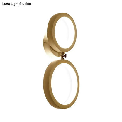 Gold-toned modernist wall lamp with two illuminated circular light fixtures for bedroom corners