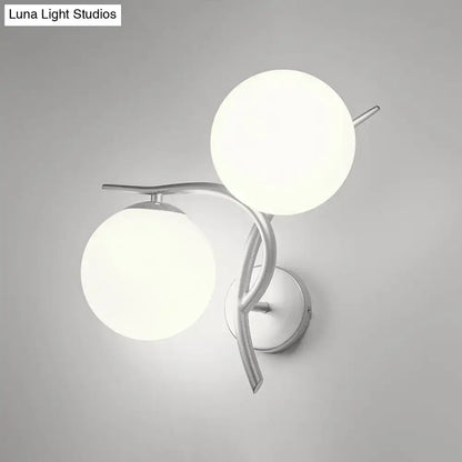 Modern two-light wall sconce with sleek silver black arms and milky glass shades for bedroom light fixture