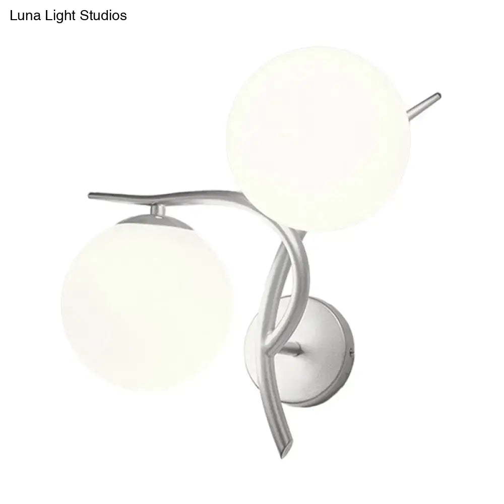 Modern double-globe wall sconce light fixture with silver black metal arms and milky glass globes for bedroom use