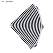 A sleek semi-circular black and silver wall lamp with concentric stripes for modernist living room lighting