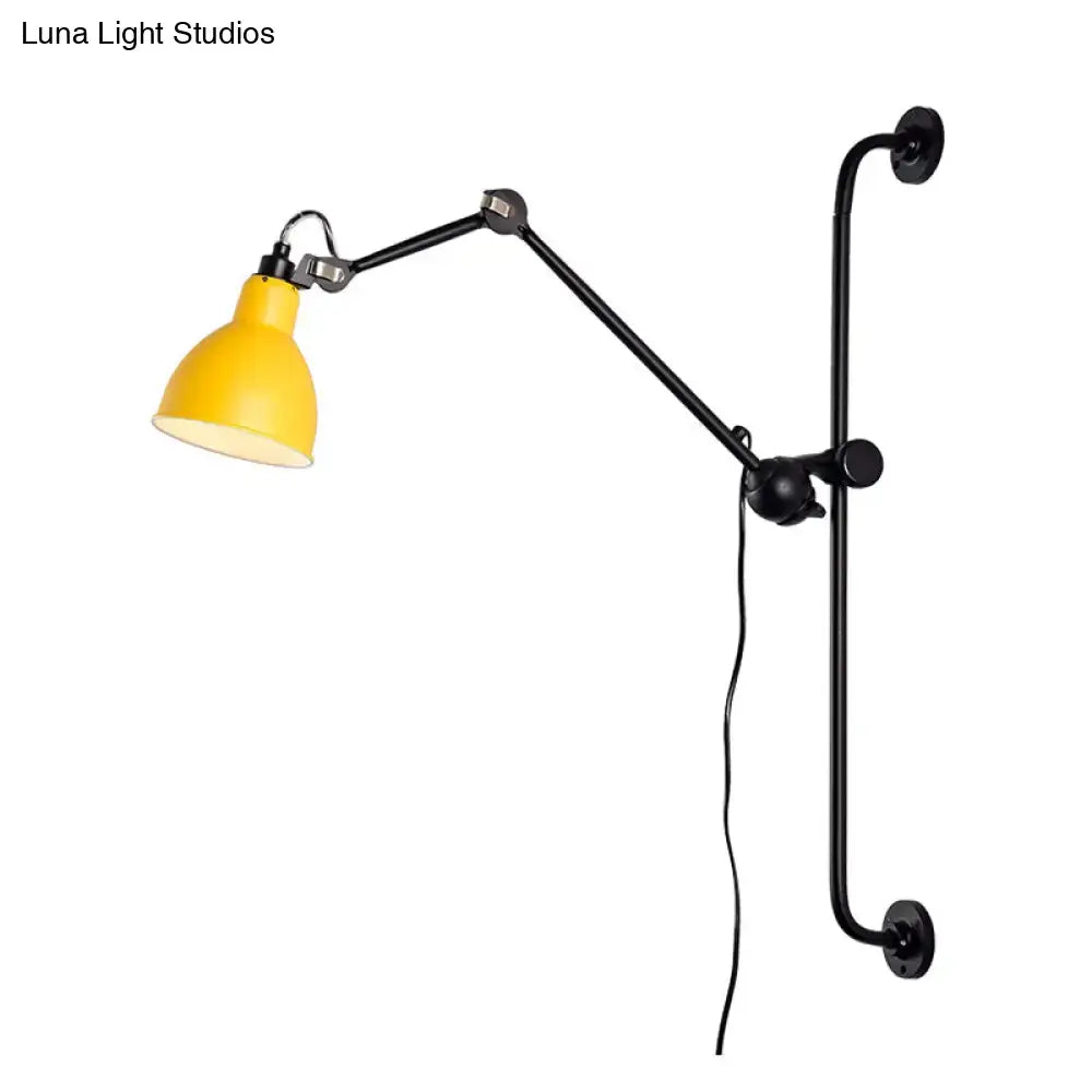 Yellow bell-shaped lampshade on black articulated arm wall light in modernist style for black white dining room