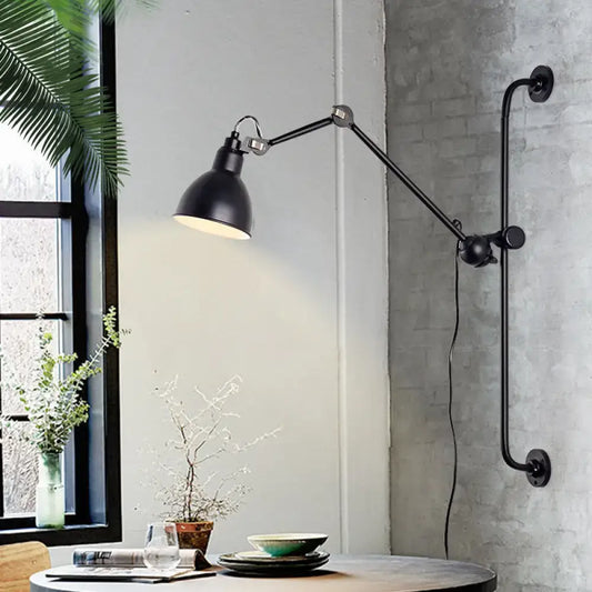 Black industrial-style wall light with articulated arms and matte finish in modernist style for dining room use