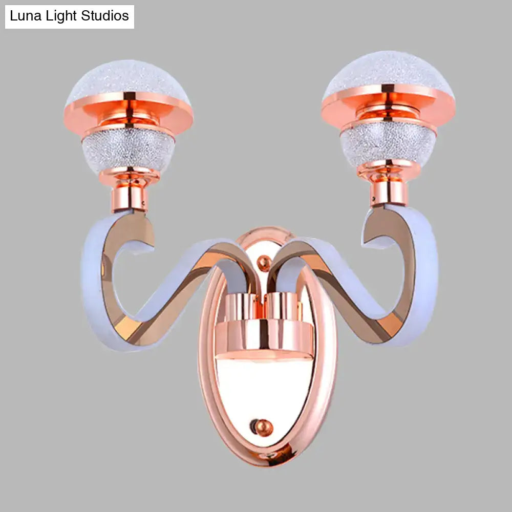 Modernist urn shape rose gold wall sconce with two curved arms and frosted glass globes for bedroom lighting