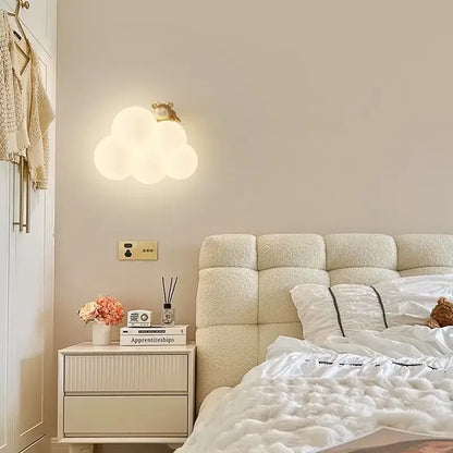 A soft glowing decorbites cloud cartoon wall lamp with warm white light and a golden bear for nursery bedroom
