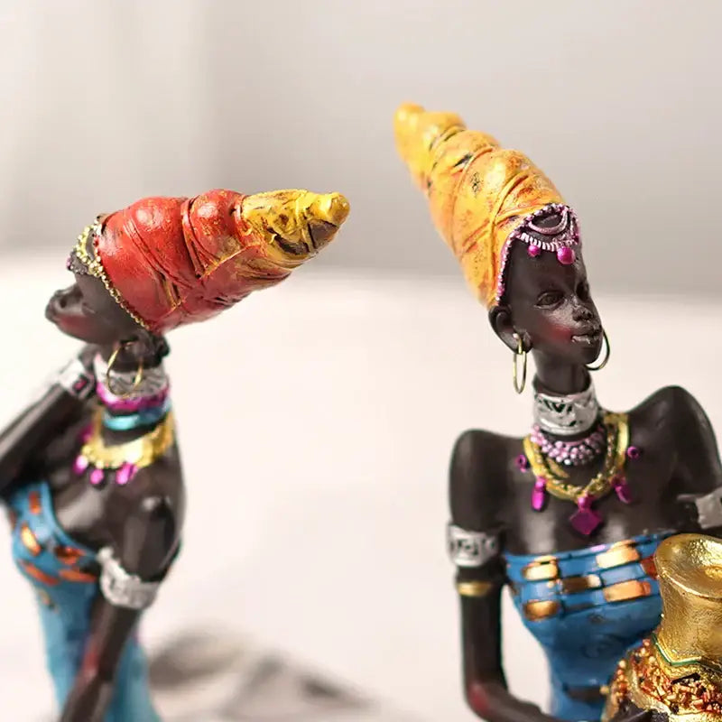 Two intricately detailed black women resin figurines with vibrant headwraps for decorbites black women living room decor