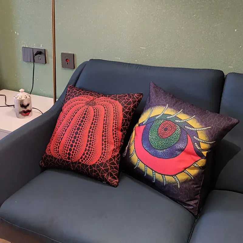 Two decorbites cotton pumpkin pillowcases with red pumpkin and eye motifs on dark gray sofa for living room decor