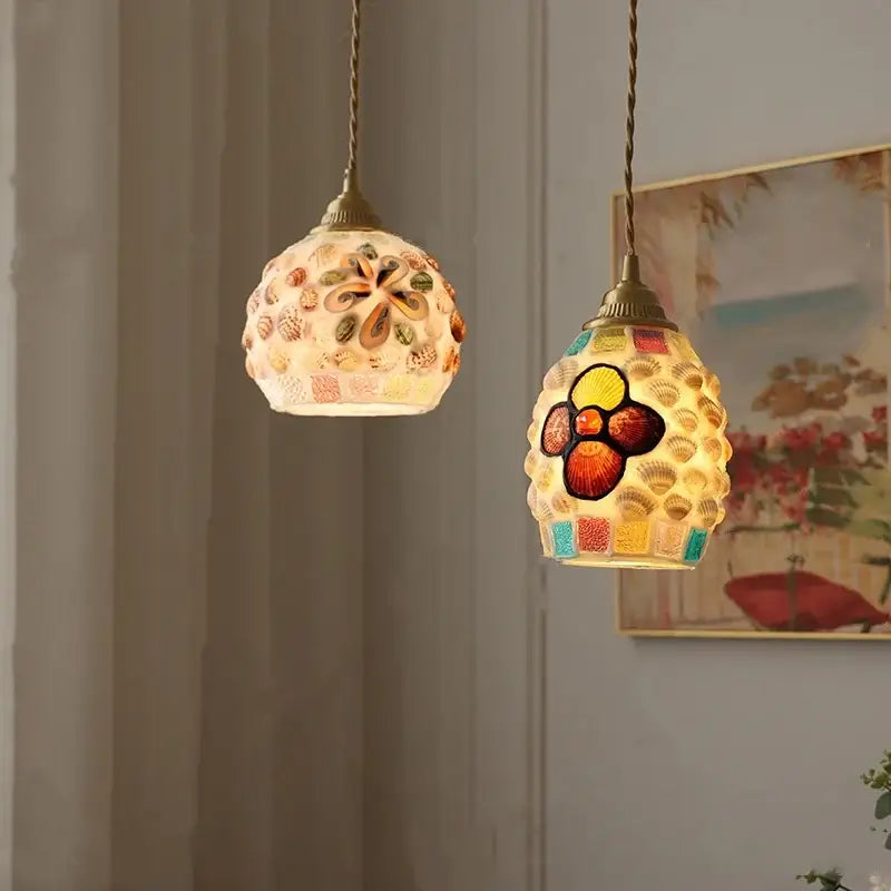 Two ornate pendant lights with mosaic shell and glass designs in warm tones by decorbites conch glass led for dining room decor