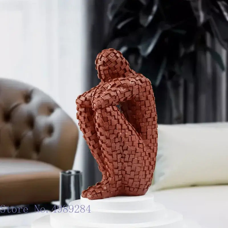 A terracotta golden man thinker abstract statue with intricate weaving seated with bowed head for living room decor