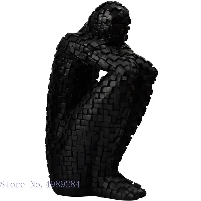 Black mosaic style figurine of a seated golden man thinker constructed from interlocking square tiles for living room decor