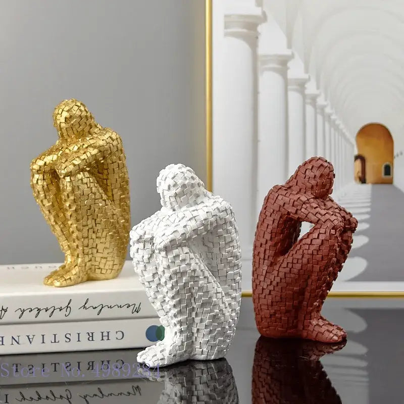 Three abstract golden man thinker statues with mosaic tile texture in gold white and terracotta for living room decor