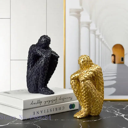 Two sculptural bookends in matte black and glossy gold featuring textured woven golden man thinker design for living room decor