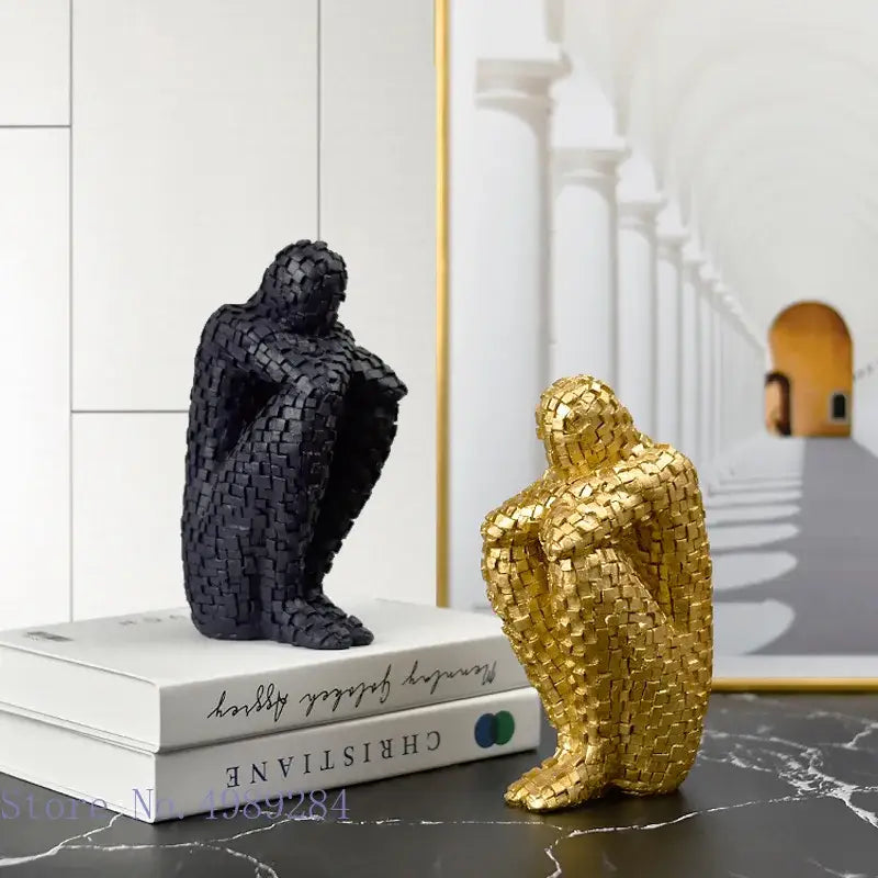 Two sculptural bookends in matte black and glossy gold featuring textured woven golden man thinker design for living room decor