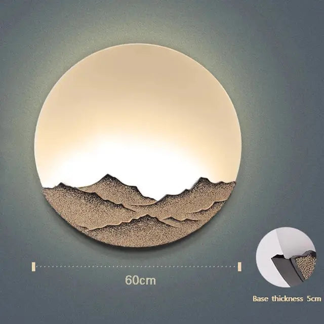 Circular Mountain landscape led wall light by decorbites featuring warm glow and textured beige and brown silhouette
