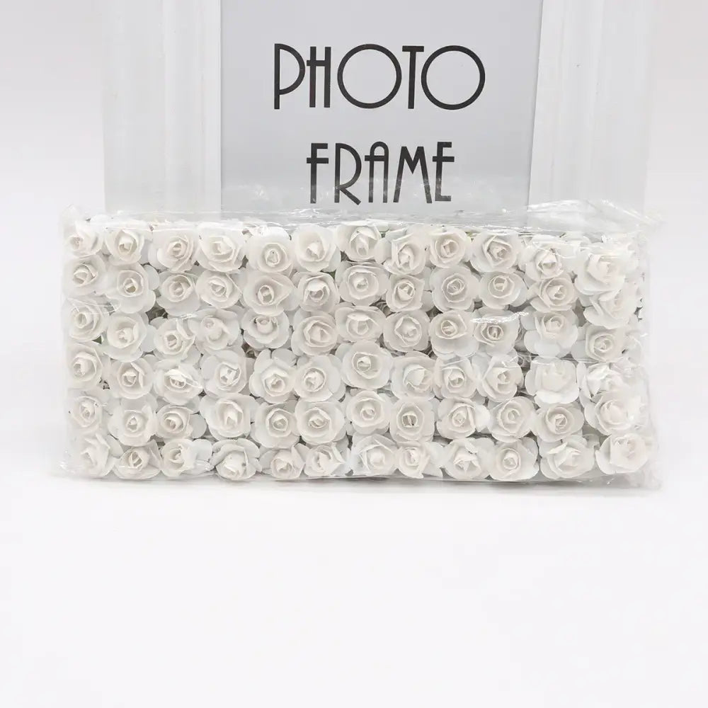 A package of delicate white 144pcs 2cm artificial paper roses neatly arranged for wedding decor by decorbites