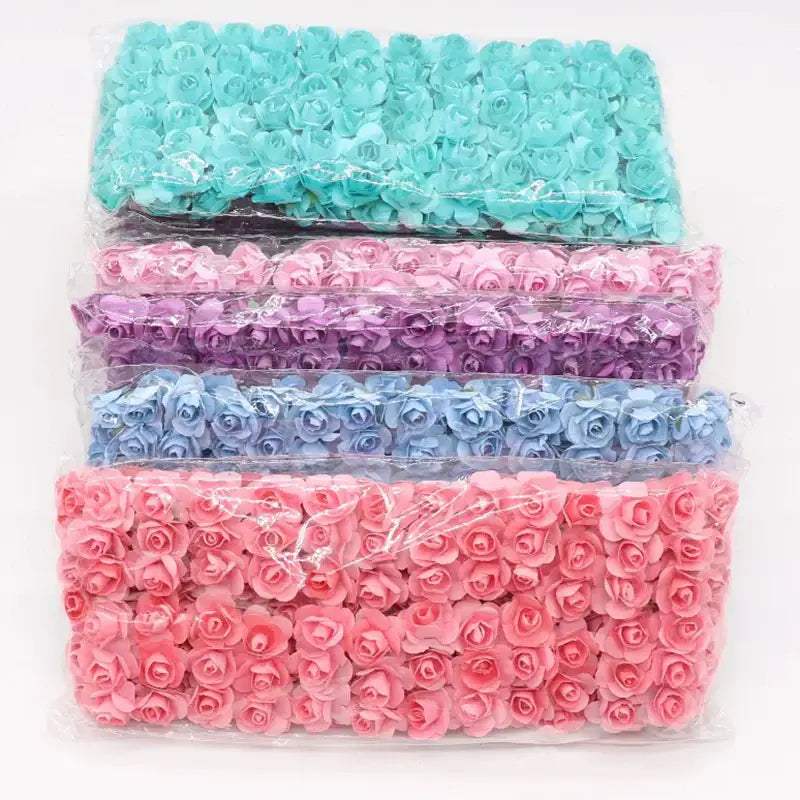 Stacked packages of pastel teal lavender light blue and pink 144pcs 2cm artificial paper roses for wedding decorbites decor