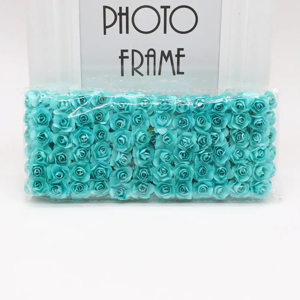 A package of decorbites 144pcs 2cm turquoise foam artificial paper roses for wedding decor and bedroom arrangements