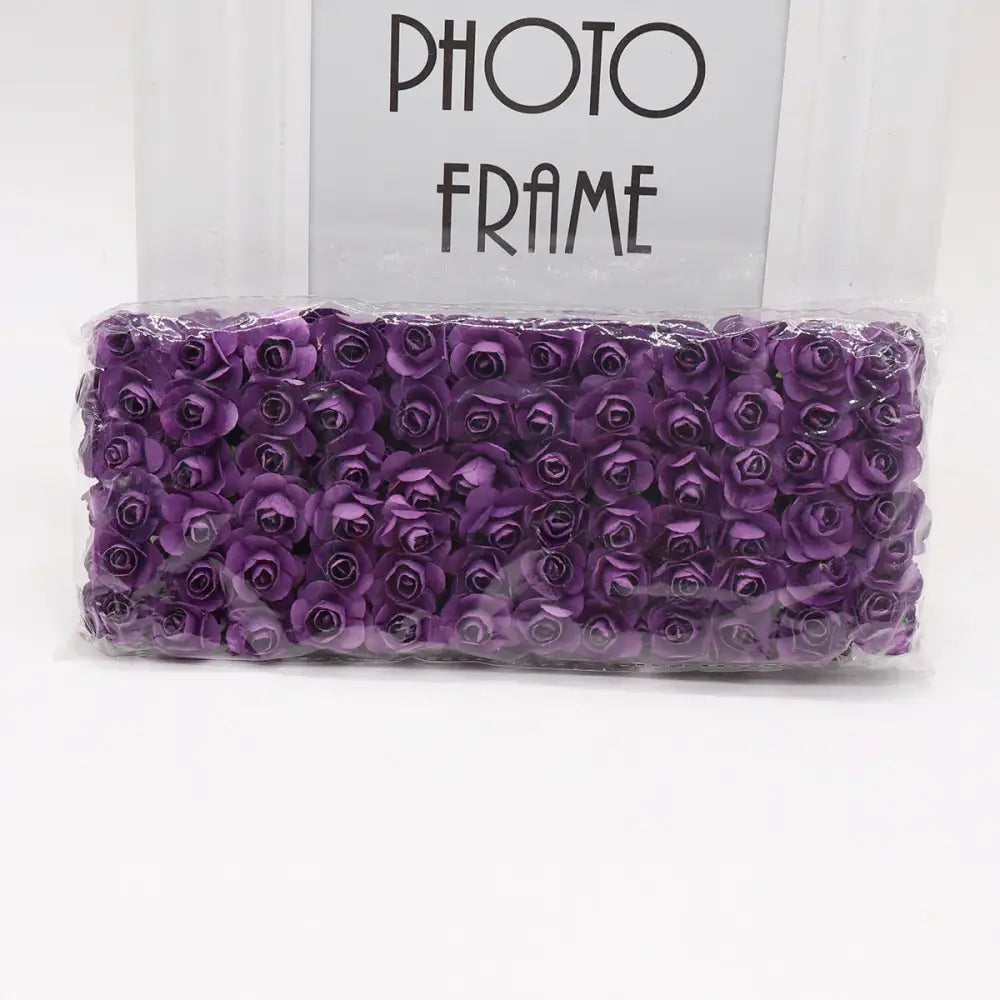 A package of decorbites 144pcs 2cm vibrant purple artificial paper roses neatly arranged in clear plastic for wedding decor