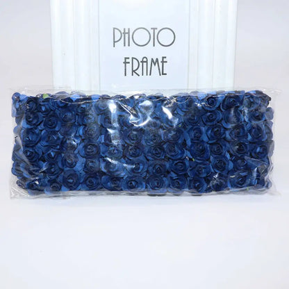 A package of navy blue decorbites 144pcs 2cm artificial paper roses neatly arranged and sealed in clear plastic packaging