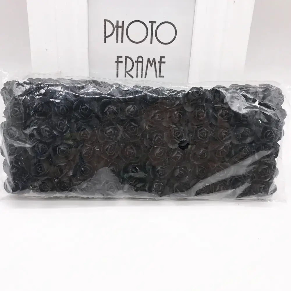 A package of black 144pcs 2cm artificial paper roses by decorbites neatly arranged for wedding decor or bedroom use