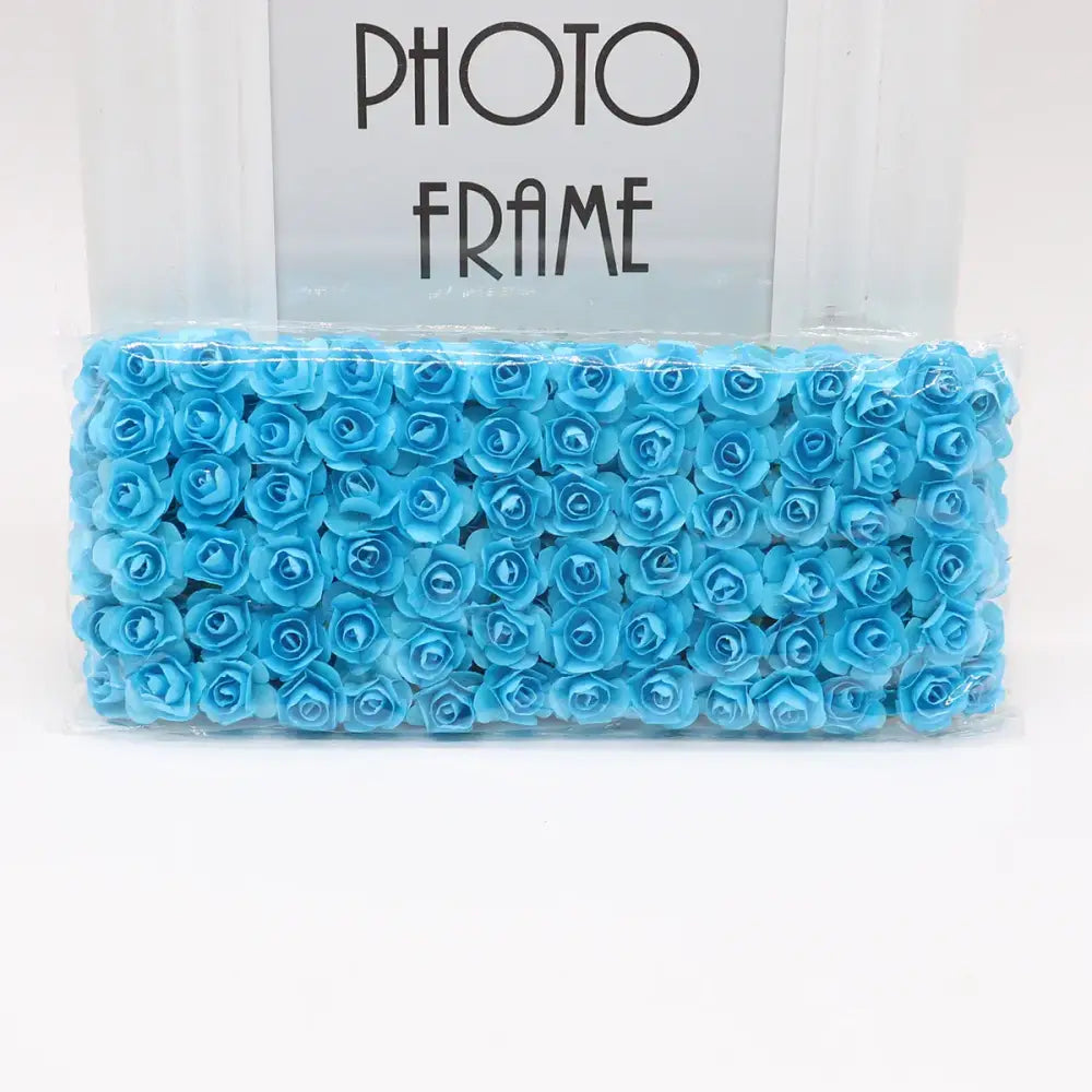 A package of light blue decorbites 144pcs 2cm artificial paper roses neatly arranged and sealed in clear plastic for decor