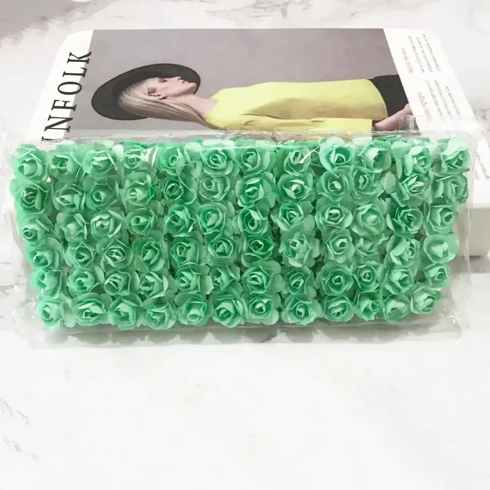 A package of mint-green 144pcs 2cm artificial paper roses by decorbites for wedding decor and bedroom use sealed in plastic