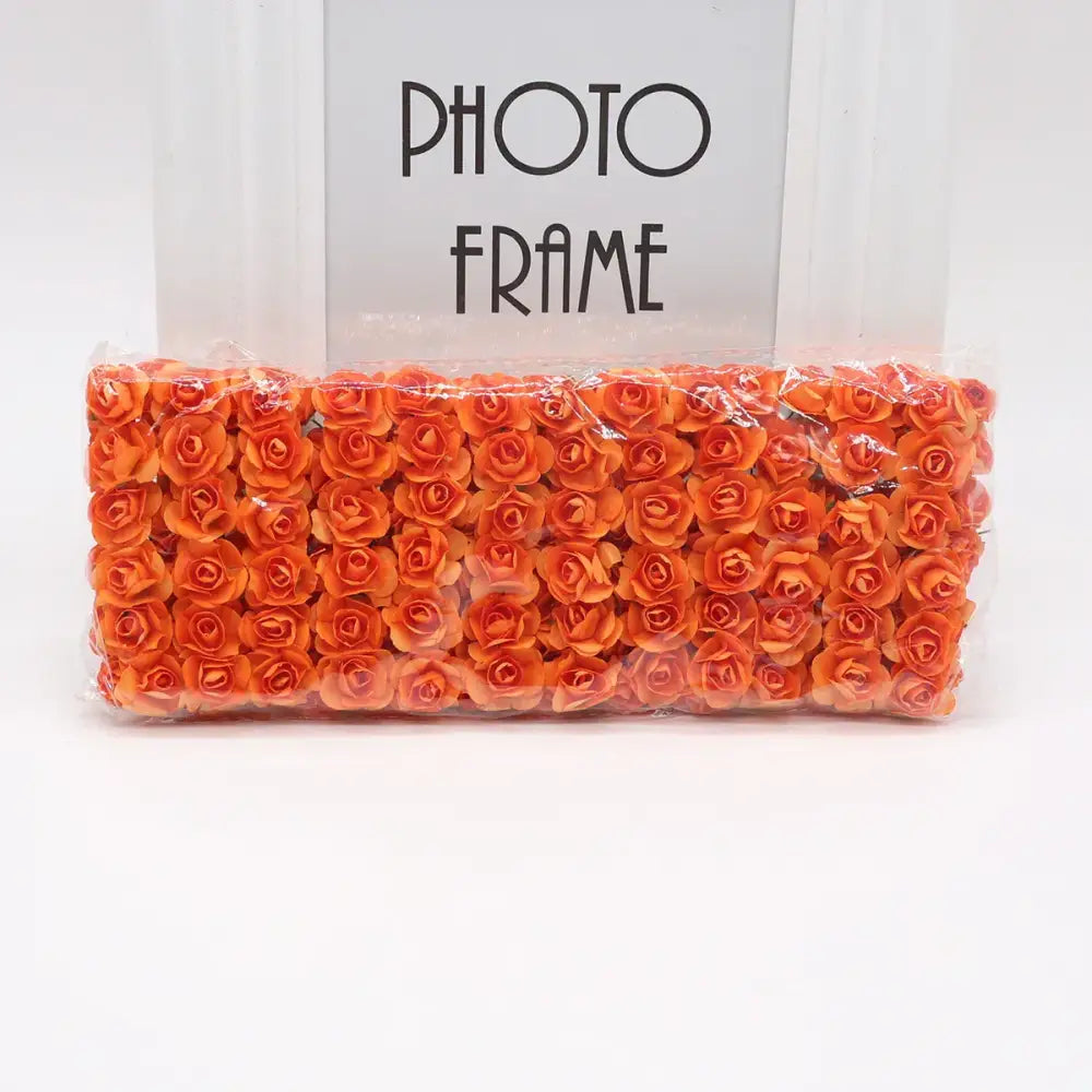 A package of vibrant orange 144pcs 2cm artificial paper roses from decorbites for wedding decor and bedroom use
