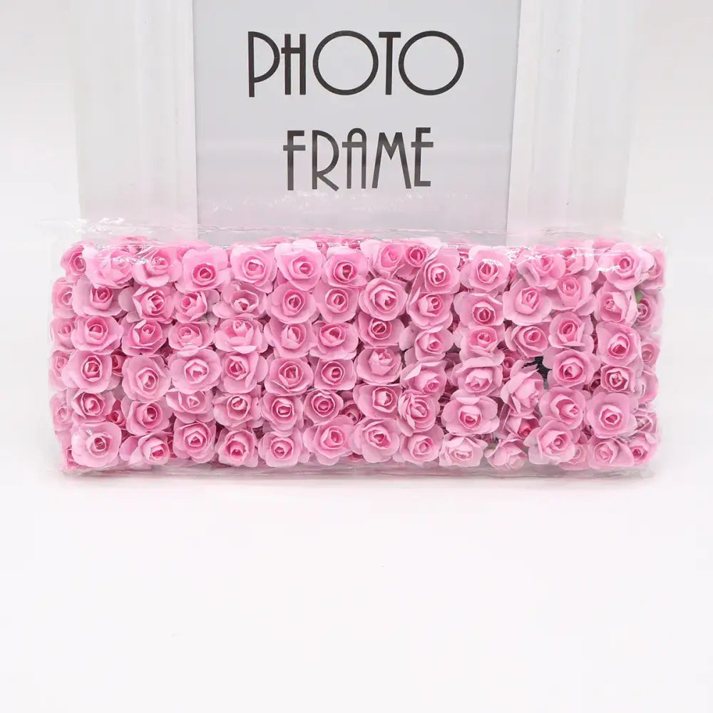 A package of delicate pink decorbites 144pcs 2cm artificial paper roses neatly arranged for wedding decor