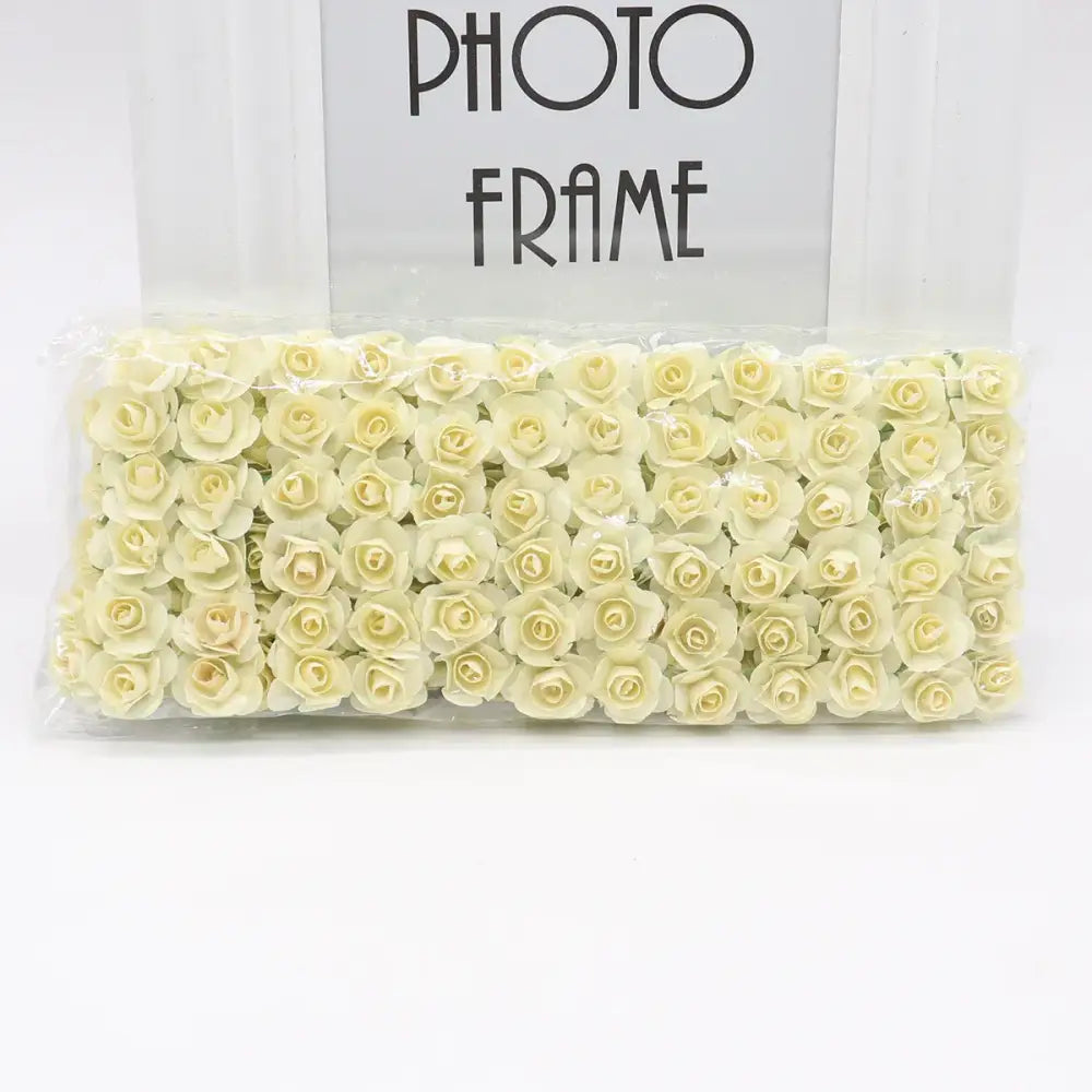 A package of delicate cream-colored 144pcs 2cm artificial paper roses neatly arranged in clear plastic for decorbites decor