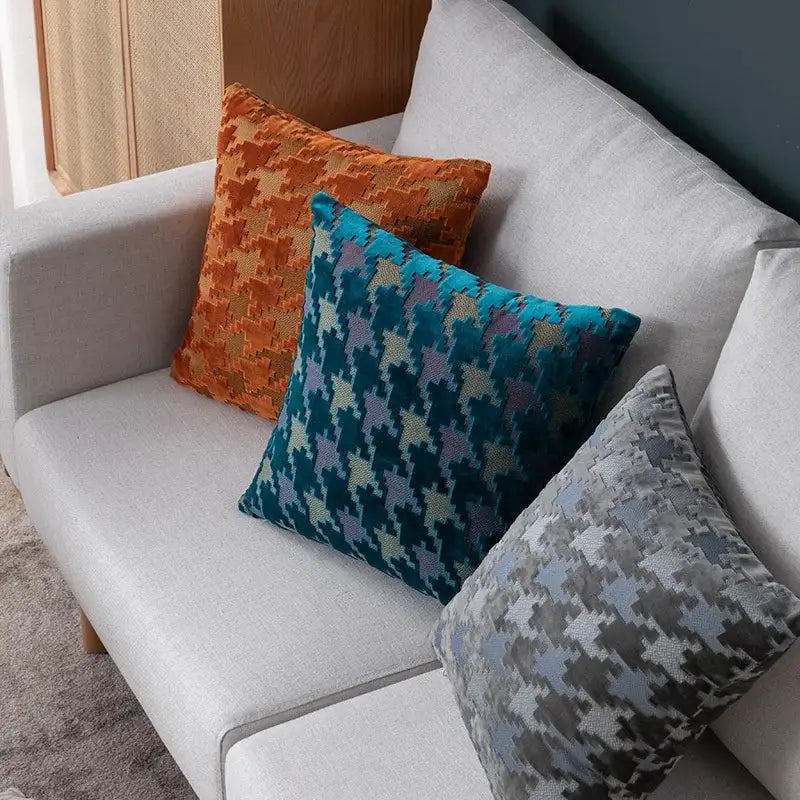 Three multicolor houndstooth luxury pillow covers in orange teal and gray tones on a light sofa for decorbites pillow cover decor