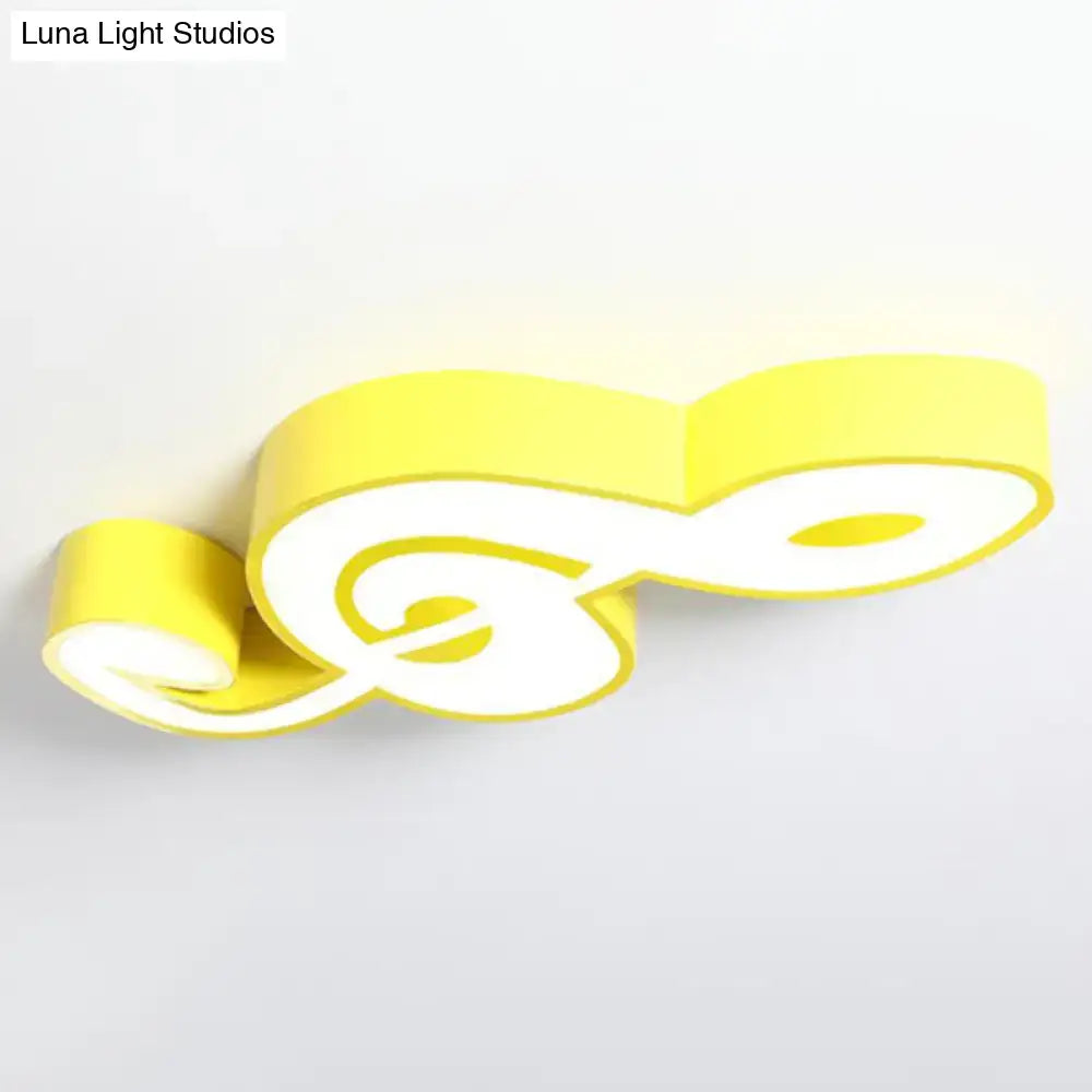 A modern yellow and white acrylic musical note led ceiling light shaped like a treble clef for kindergarten use